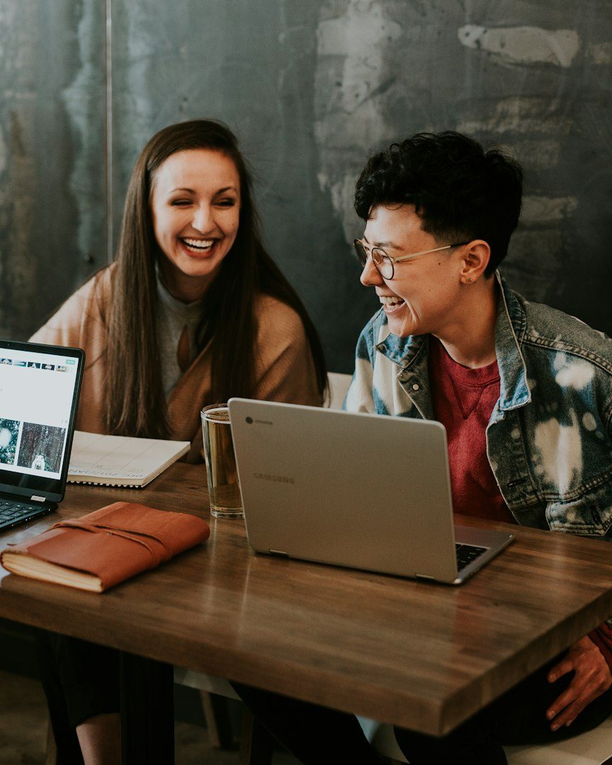 Two students working together on a laptop